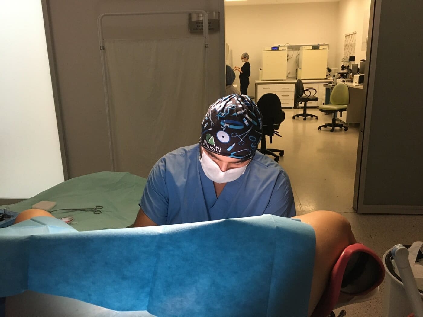 Gynecologist performing medical procedure in operating room with sterile equipment