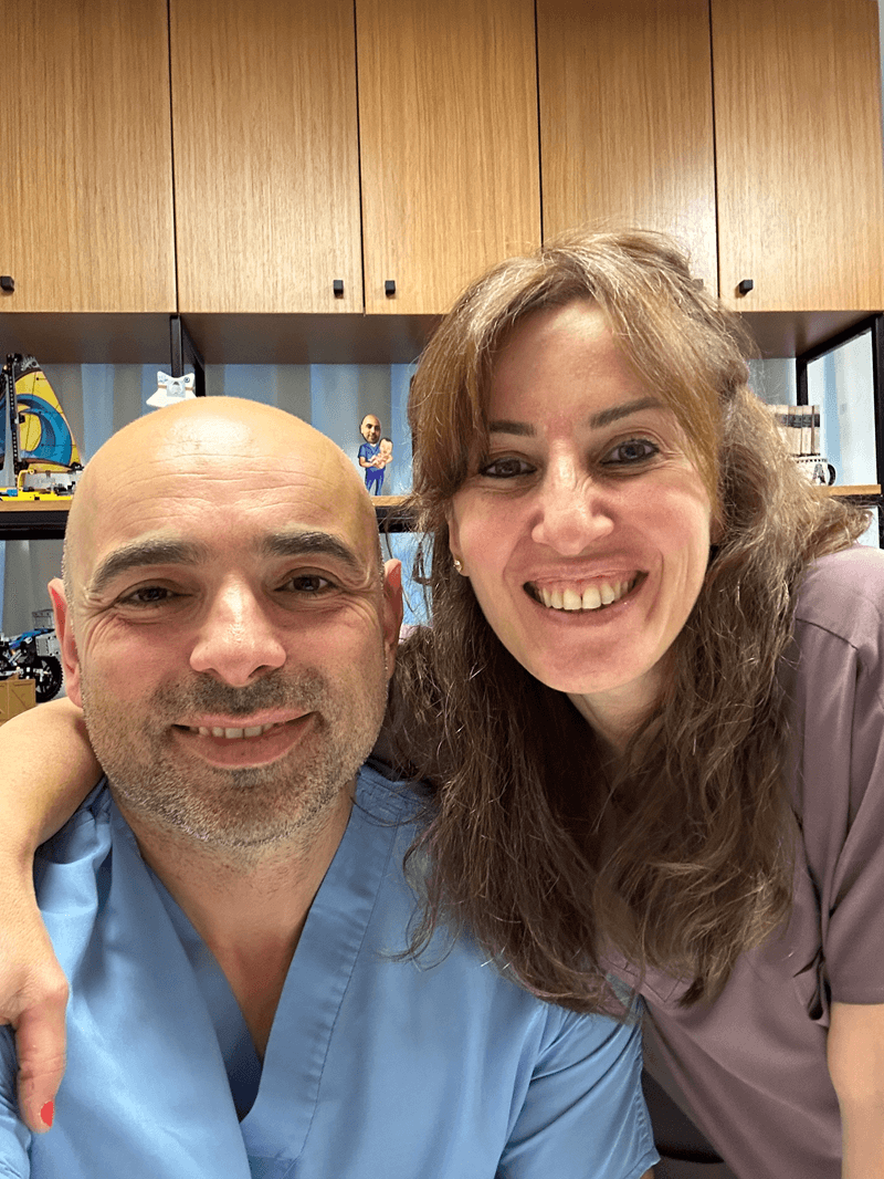 Smiling healthcare professionals taking a selfie in a clinic office with medical scrubs